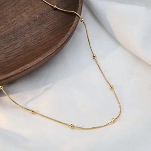 Elegant 18k gold plated stainless steel snake chain necklace with bead accents on silk