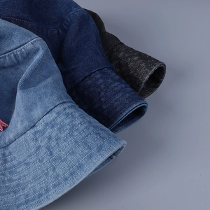 Detail von Denim-Anglerhüten mit parallelen Krempennähten in Blau- und Schwarztönen