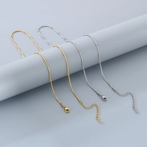 Detail of adjustable stainless steel snake chain necklace with lobster clasp and gold finish