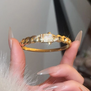 Macro shot of gold-plated Cuban link bracelet with sparkling pavé cubic zirconia center