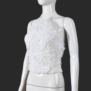 Detail of white popcorn fabric crop top showing textured material and halter neck on mannequin