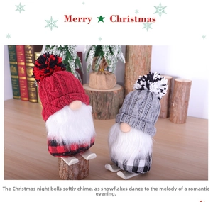 Close-up of plush Christmas ski gnomes with knitted hats and wooden bases on a festive table