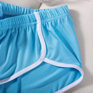 Detailansicht des himmelblauen Netzgewebes und der weißen Paspelierung an Sportshorts