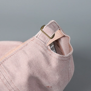 Close-up of vintage bronze metal buckle and washed cotton fabric on the baseball cap