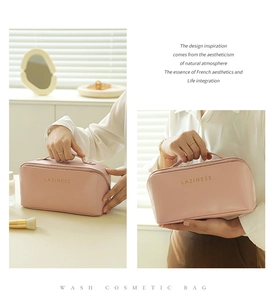Detail of pink leather cosmetic bag with gold lettering and top handle for travel