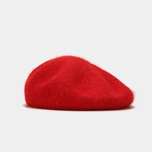 Détail du béret en tricot rouge avec texture en fourrure et accents de paillettes fines