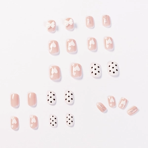 Nude thee kunstnagels set met witte stippen en strikjes voor een elegante look