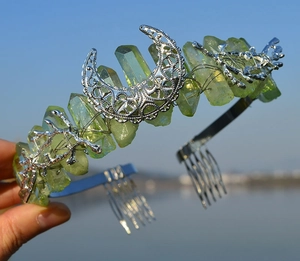 Close-up of bohemian moon crystal crown with light green stones and silver metal base