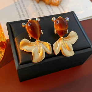Macro detail of vintage gold fish earrings with teardrop opal stones and crystals