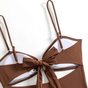 Detailweergave van bruine bikinitop met verstelbare bandjes en strikdecoratie