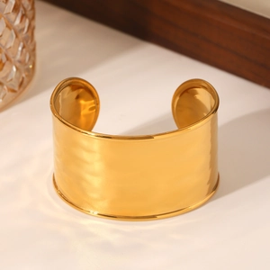 Detailed close-up of 18K gold plated wide cuff bangle with textured hammered surface