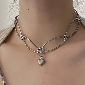 Close-up of Y2K silver star beaded chain necklace with heart pendant on model