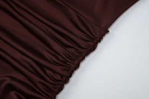 Dettaglio macro della trama del tessuto arricciato rosso vino e del design a pieghe