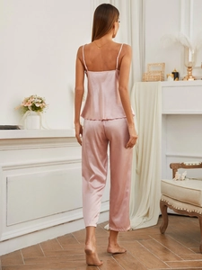 Rear view of a soft pink satin pajama set with a spaghetti strap top and trousers