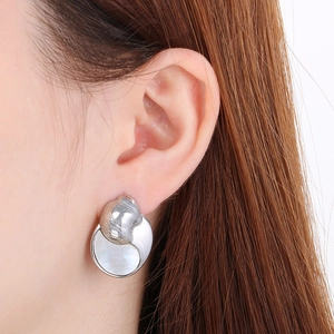 Close-up of minimalist crescent shell earrings in polished stainless steel on model