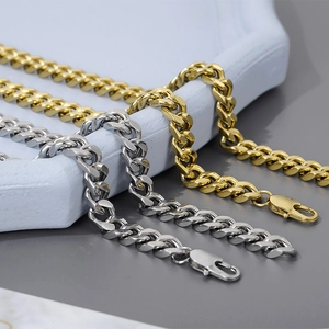 Close-up of classic Cuban link necklaces in gold and silver stainless steel finishes