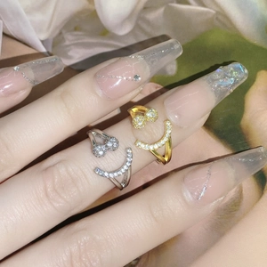 Close-up of gold and silver smiley face open rings with sparkling crystal embellishments