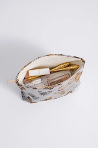 Top view of large butterfly print makeup bag filled with cosmetics and brushes