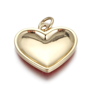 Macro shot of a polished heart-shaped gold pendant with a smooth reflective mirror finish