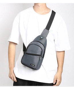 Close-up of grey waterproof oxford chest bag featuring multi-layer zipper compartments