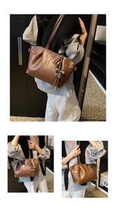 Close-up of brown pleated tote bag featuring a cute cat charm and soft leather texture