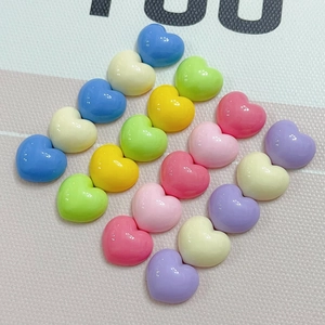 Close-up of colorful heart resin cabochons in glossy macaron shades for DIY crafts