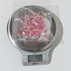 Weight measurement of 5pcs pink acrylic snowflake ornaments on a digital scale