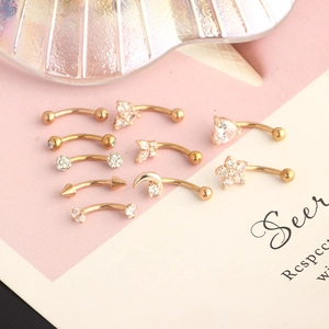 Detail of gold piercing jewelry set featuring butterfly star and moon shapes with zircons