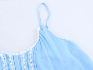 Detailed view of light blue pleated fabric with white lace trim and thin shoulder straps