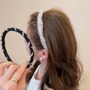 Detail of elegant mesh headband featuring delicate rhinestones and white lace texture