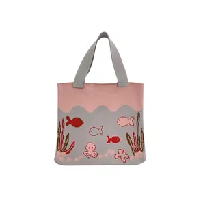 Pink and grey knitted ocean tote bag with fish and octopus patterns on white background