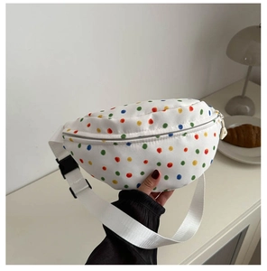 Detail of white canvas waist bag with colorful polka dots and black plastic buckle