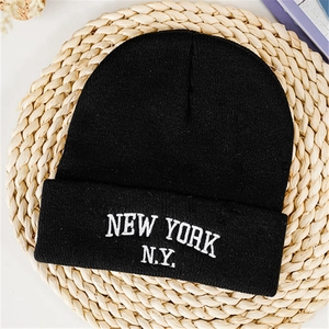 Detailed close-up of New York N.Y. embroidery on a black knitted winter beanie