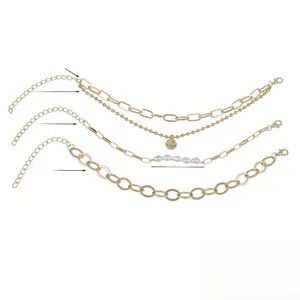 Detailed close-up of triple-layered gold bracelet set with pearl and LOVE heart pendant