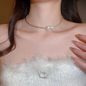 Detailed view of silver choker necklace featuring twin pearls on a model's neck