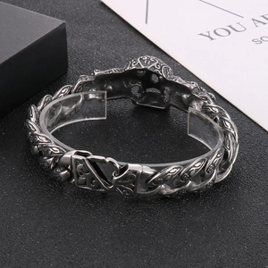 Détail du bracelet tête de mort argenté avec yeux rouges et gravures florales