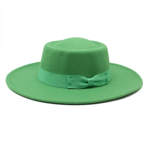 Close-up of grass green wool boater hat featuring a matching grosgrain ribbon and bow