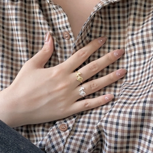 Close-up of adjustable leaf-shaped rings in gold and silver finish on hand