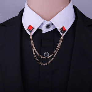 Close-up of golden geometric collar chain with red square stones on white shirt