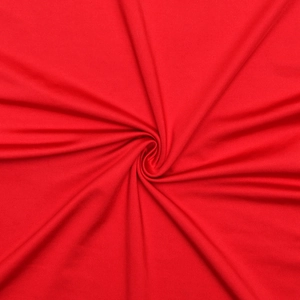 Dettaglio del tessuto in pizzo rosso con trama morbida e drappeggio a spirale elegante
