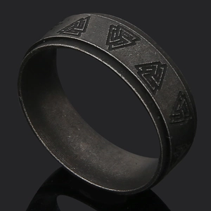 Macro shot of vintage black titanium steel ring featuring engraved Nordic Valknut symbol