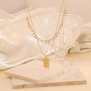 Détail du collier double couche doré avec perles colorées et pendentif soleil céleste