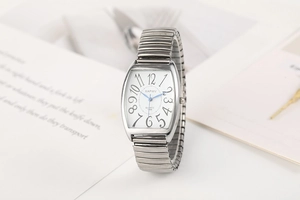 Détail d'une montre tonneau argentée à quartz avec bracelet extensible et gros chiffres