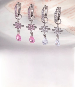 Macro shot of silver star hoop earrings with micro-inlaid cubic zirconia and drop pendants