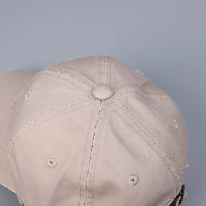 Detailed top view of cotton baseball cap showing ventilation holes and fabric texture