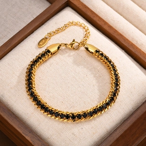 Detail of gold chain bracelet with black zircon inlay and K18 hallmark tag in a jewelry box