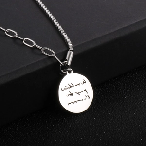 Detail of silver round pendant necklace with engraved Arabic text on mixed link chain