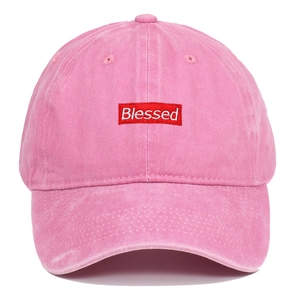 Detail of pink washed cotton baseball cap with red Blessed rectangular embroidery