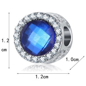Dettaglio macro di un ciondolo in argento con gemma blu e strass da 1,2 cm