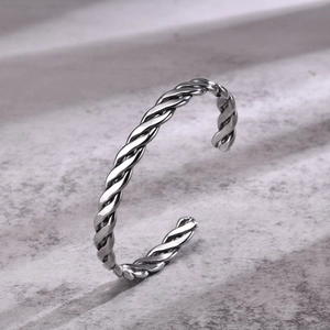 Detail view of silver men's open cuff bracelet with twisted rope vintage metal texture